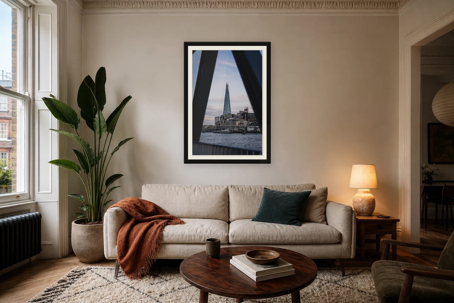 The Shard Between Shadows print shown with a small white mount in a black frame above a sofa.